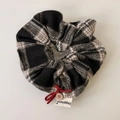 Dettaglio scrunchie a scacchi con fiocco rosso, bottone in legno ed etichetta Happiness - Scrunchie scozzese nero