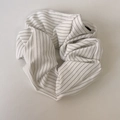 Dettaglio ravvicinato di elastico scrunchie bianco a sottili strisce nere in tessuto - Stile di base / Scrunchie Bianco Sporco