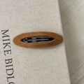 Vista detallada de la pinza BB de terciopelo marrón con elegante textura de base metálica - Caramelo Ovalado