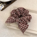 Macro di un elastico per capelli a quadretti marrone rosso con fiocco elegante - Quadri Rosso Bianco