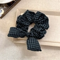 Detail of dark green plaid scrunchie with bow tie texture on beige textured background - Misty Blue Plaid