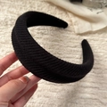 Close-up detail of the black knitted wide headband showing thick ribbed fabric texture - Black