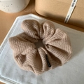 Detalle de coletero de punto marrón claro con etiqueta de moda en tela acolchada - Caqui