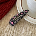 Detail einer trendigen Leopard-Haarklammer auf einem weichen Stoffhintergrund - Wassertropfen Rosa Leopardenmuster