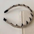 Detalle de una diadema de pana gris claro con dientes para un peinado estable y fijo - Blanco Roto