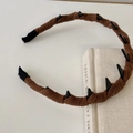 Detail of coffee brown knit headband featuring edgy black cone spikes and ribbed ends - Brown