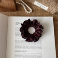 Detailed close-up of a burgundy faux leather scrunchie with retro pleated texture - Burgundy