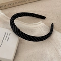 Détail d'un serre-tête en tissu à rayures noires avec broderie dorée sur un pull - Serre-Tête Fin Noir