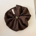 Close-up of brown textured scrunchie with a hand made label on a white surface - Dark Brown