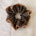 Detailed shot of vintage brown and grey plaid scrunchie with ruffled khaki trim - Coffee