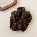 Detail of striped knitted scrunchie in brown and yellow with soft wool-like texture - Brown