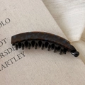 Detail view of the tortoiseshell banana clip with a smooth finish and curved comb design - Blue Brown Gradient