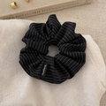 Close-up of a premium black and white striped oversized scrunchie on soft knit texture - Black Scrunchie