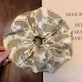 Dettaglio di un elastico per capelli vintage con stampa paisley e bordo in pizzo - Stile Base Vintage