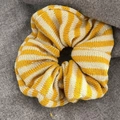 Texture détaillée d'un chouchou en tricot rayé jaune et blanc sur fond gris neutre - Rayures Jaunes