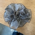 Dettaglio del ricamo in pizzo grigio e delle texture increspate di un grande elastico per capelli - Grigio