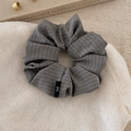 Detailed view of grey striped fabric scrunchie with subtle ribbon bow tag detail - Dark Gray Scrunchie