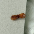 Dettaglio del fermaglio a fiocco in acetato marrone ambra con strass scintillanti - Marrone