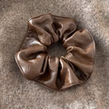 Detailed view of dark brown leather scrunchie with fine stitching on wool fabric - Brown