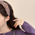 Detail eines altrosa Strickstirnbands mit einer dekorativen Schildpatt-Ringschnalle - Lila