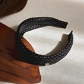 Detail shot of black polka dot headband with a small silver heart charm and non-slip lining - Black