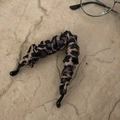 Close-up of leopard print fabric banana hair clip with elegant pleated texture on stone base - Leopard Print