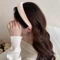 Primer plano de una diadema de terciopelo oro champán con diseño acolchado grueso - Beige