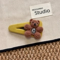 Dettaglio di fermaglio in tessuto giallo con orsetto di peluche marrone e gemma lucida - Stile Orso Giallo