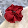 Primer plano de un coletero rojo con lunares sobre tela texturizada con detalles - Rojo