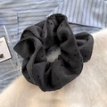 Detalle de un coletero negro con lunares en tela texturizada sobre una camisa a rayas - gris oscuro