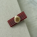 Dettaglio macro della molletta rossa rettangolare con strisce bianche e pietra in resina - Rosso