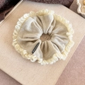 Macro detail of a beige oversized knitted scrunchie with a soft wool-like texture - Off-white