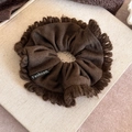Detail of coffee brown knitted scrunchie with soft loop edges and Fashion label tag - Brown