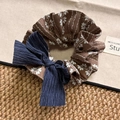 Detail von Vintage-Haargummi mit braunem Blumenmuster und dunkelblauer Cord-Schleife - Cord-Schleifen-Haargummi