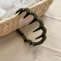 Detail of olive green knitted headband with inner teeth and handmade fabric label - Wavy Headband / Green