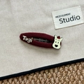Gros plan d'une pince à cheveux en tissu rouge avec logo Tagi et motif de petit chien - Barrette Chien en Tissu Rouge Foncé (Tagi)