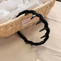 Detail of black knitted headband featuring tooth grips and handmade logo marking - Wavy Headband / Black