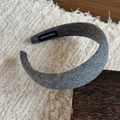 Detail view of grey wool headband featuring a sewn handmade label on the inner fabric - Gray