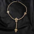 Detailaufnahme einer goldenen Rosenkranz-Kreuzkette mit funkelnden Zirkon-Perlen - 18inch / Gold