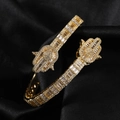 Macro shot of gold Hamsa Hand bracelet with pave white zircons on black satin - Gold 8inch Palm Bracelet