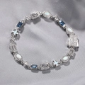 Detail of silver bracelet with blue gemstones, opal stones, and cross pendant on silk - 18inch (45cm) / Silver