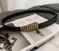 Detalle de cinturón de cuero negro con hebilla metálica dorada sobre revista de moda - 100cm / Negro