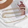 Vue détaillée de l'élégante chaîne de taille en métal doré avec perles et fermoir mousqueton - Style Perle à une Rangée