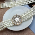 Close-up of triple-strand pearl belt featuring a crystal encrusted gold metal buckle - Large Rhinestone Style