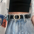 Close-up of minimalist black leather belt with golden oval buckle on blue denim jeans - 105 / Black