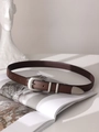 Detail of vintage brown leather belt with silver buckle on an open aesthetic magazine - Coffee