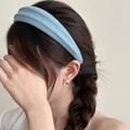 Detalle de la textura de la diadema de tela azul claro y su ajuste en el cabello trenzado - Azul claro