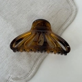 Macro view of shell-shaped tortoiseshell hair claw clip with smooth resin finish - Tortoise