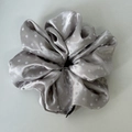 Detailed view of silver grey satin scrunchie with white polka dots and soft texture - Gray