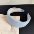 Detailed macro view showing the textured light blue knit fabric on a thick padded headband - Blue